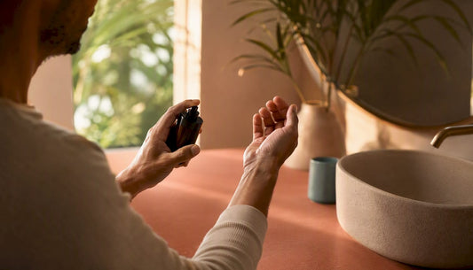 Hand holding fragrance vial near wrist
