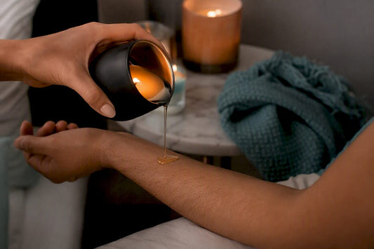 Pouring warm massage candle wax onto skin
