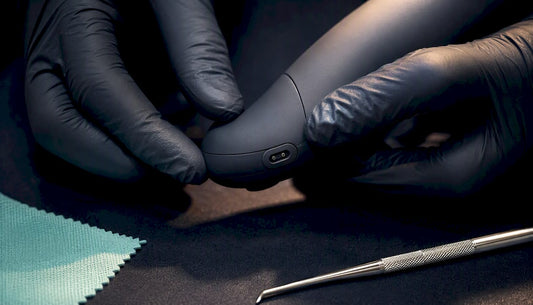 Hands inspecting an intimate wellness device detail